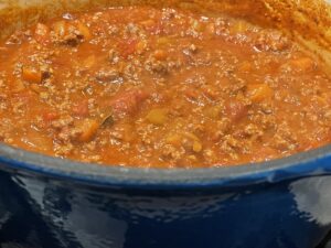 Simmer bolognese sauce in heavy pan